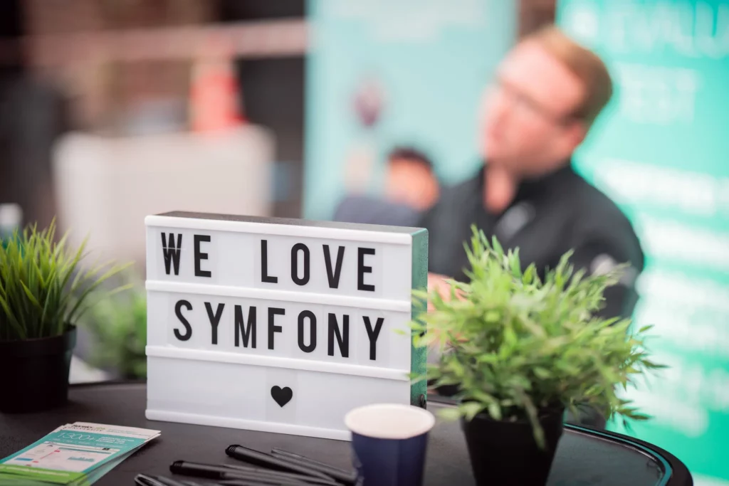 Photo du stand de Sensiolabs, lors de l'API Platform Conference 2023. Il est écrit sur leur lightbox &quot;We Love Symfony&quot;" class="wp-image-9755